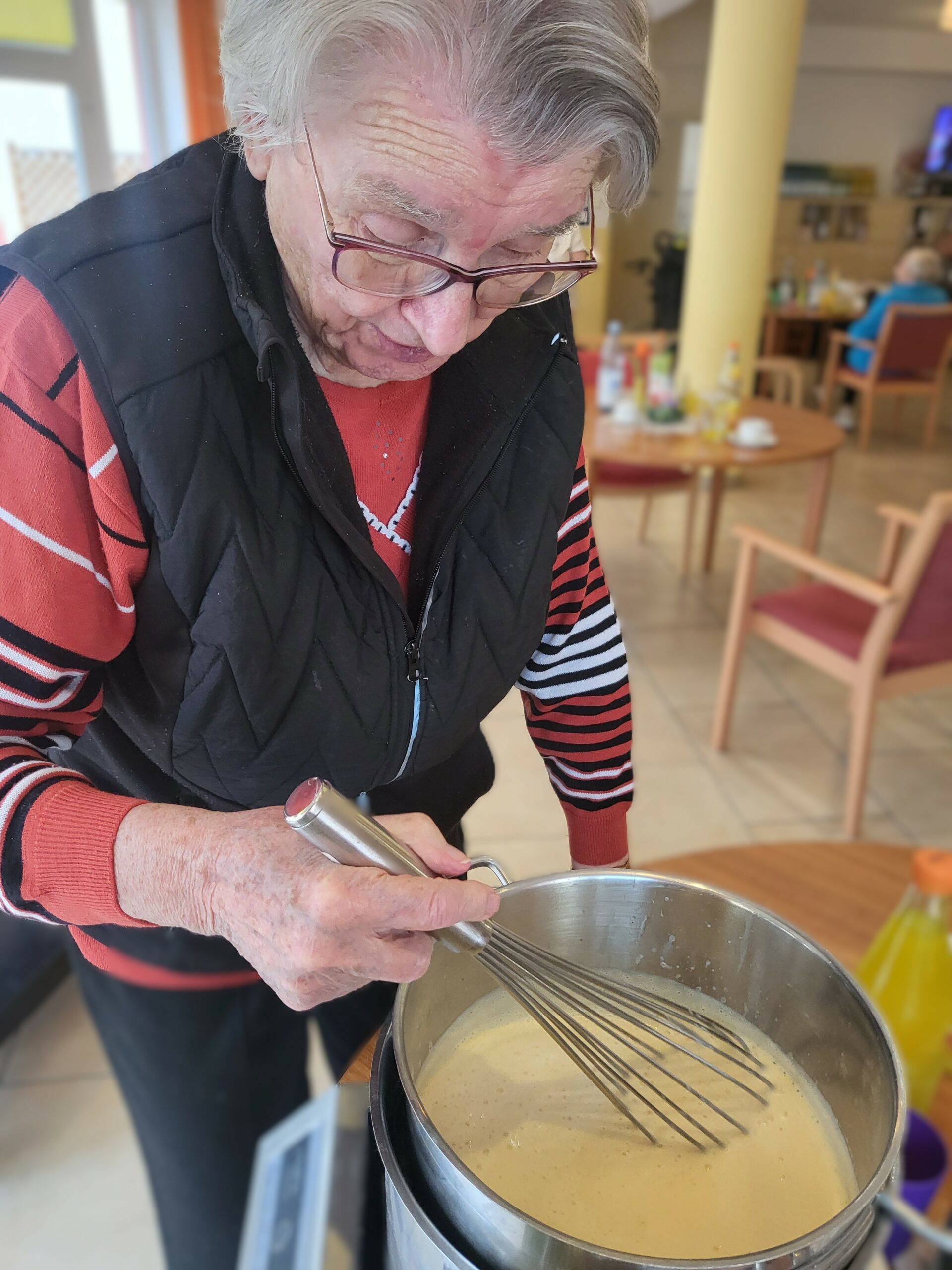 Eine Seniorin bereitet Eierlikör zu