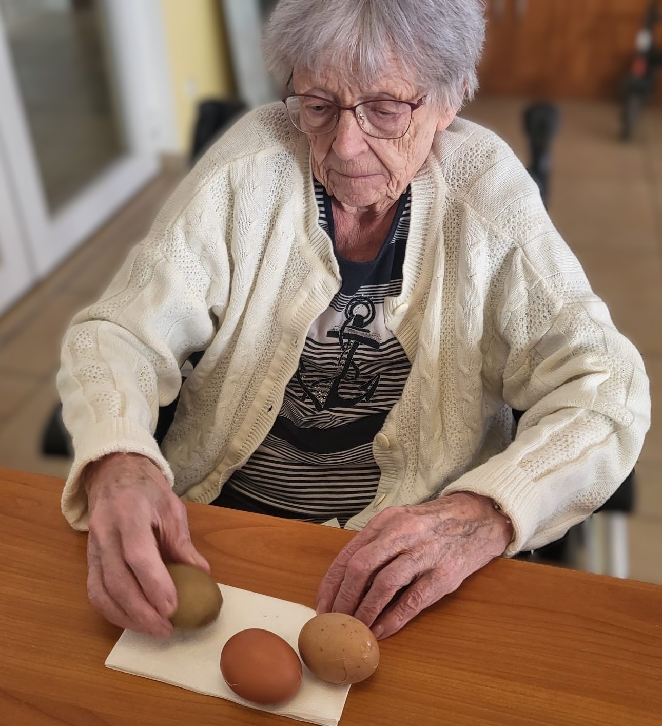 Eine Seniorin mit drei Ostereiern