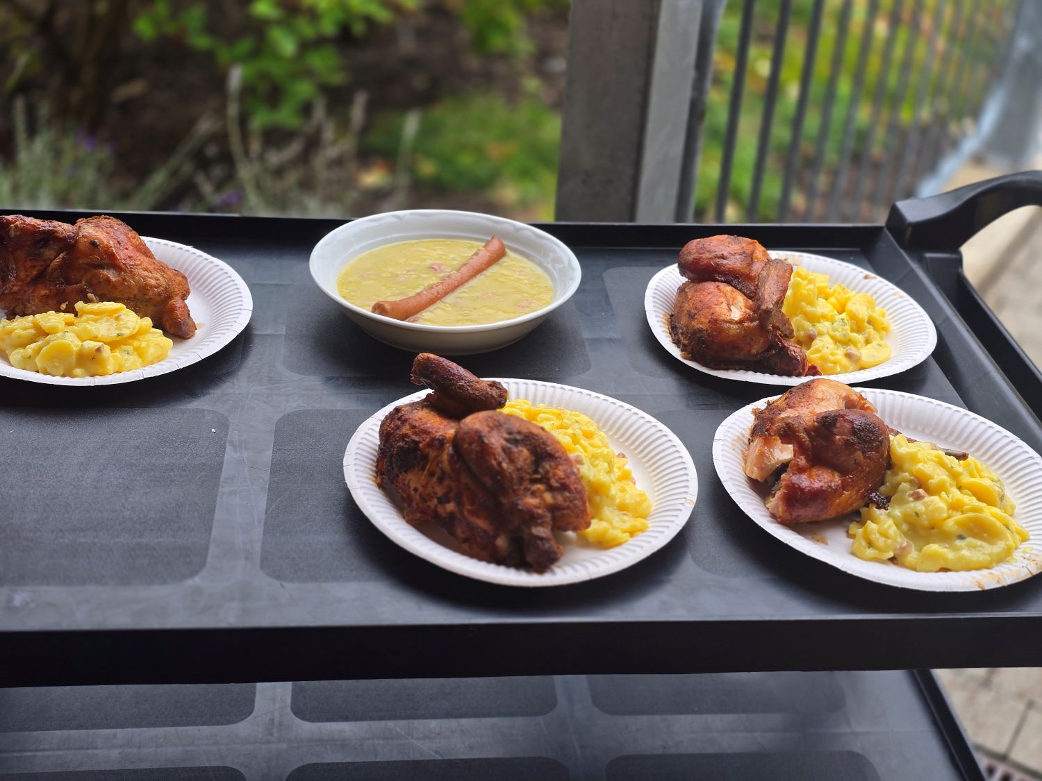 fünf volle Teller mit Hähnchen und Kartoffelsalat und Wiener mit Suppe