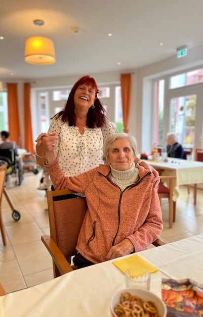 eine Bewohnerin freut sich mit einer Pflegerin